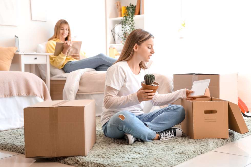 Student unpacking in a dorm room